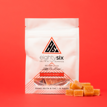 Citrus Blast Delta-8 THC Gummies with its respective mylar bag on a red background.
