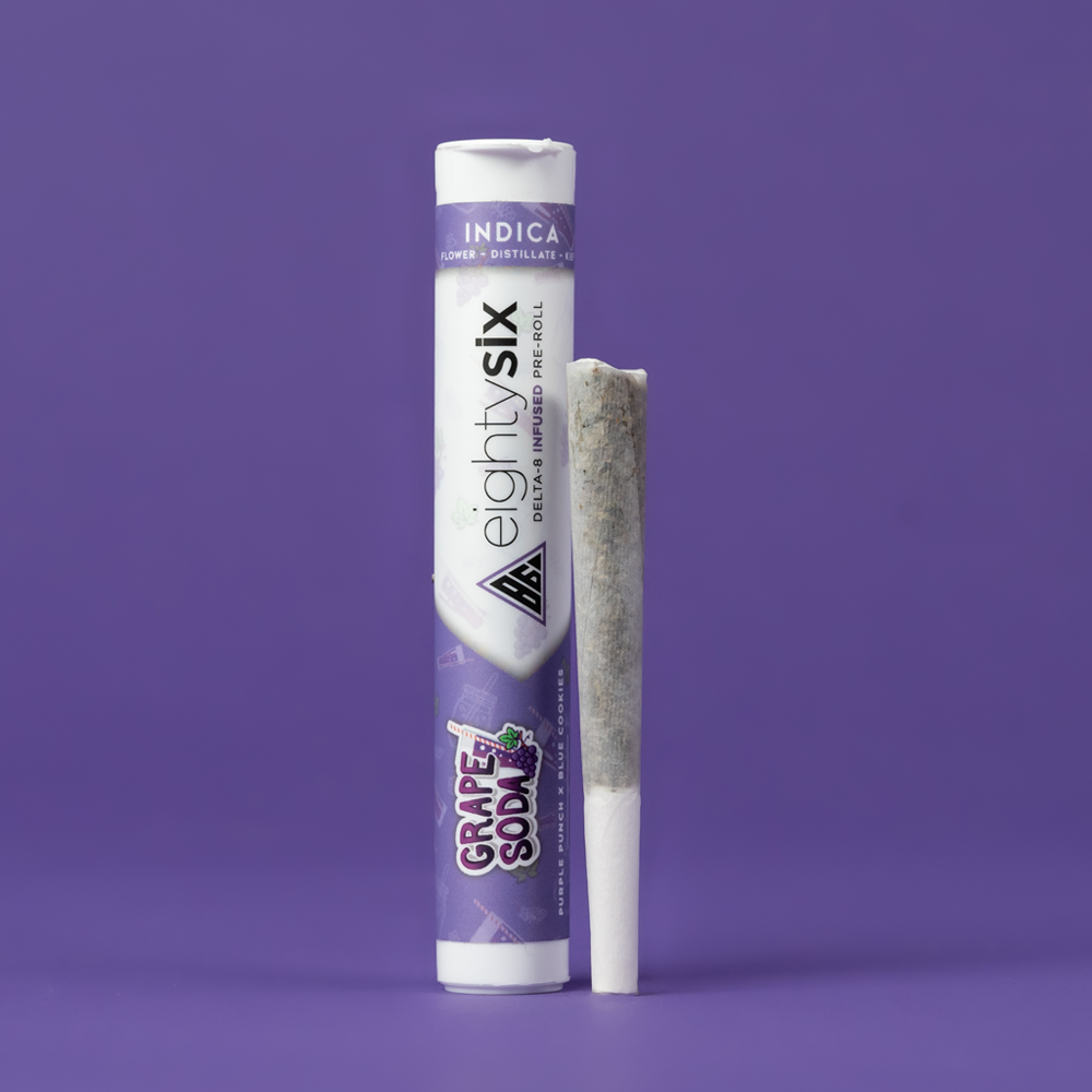 GrapeSoda-D8-PreRoll Grape Soda Delta-8 THC Pre-Roll with its respective packaging on a purple background.