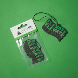 Apple Blast Air Freshener and its respective packaging on a green background.