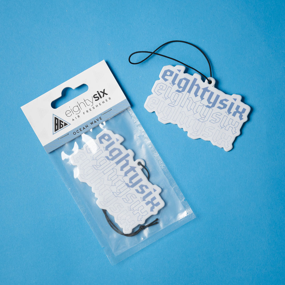 Ocean Wave Eighty Six Air Freshener The Ocean Wave Air Freshener and its respective packaging on a blue background.