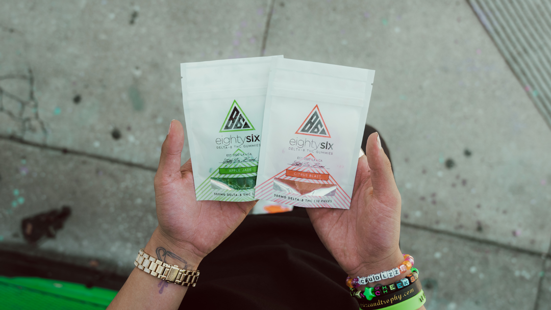 A person showing two different flavors of delta 8 thc gummies